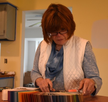 Cathy Prosek, a founder of the ACRES project, deliberates options for baseboard colors. ACRES works with adults on the Autism Spectrum to transition to independent living and learn vocational skills.